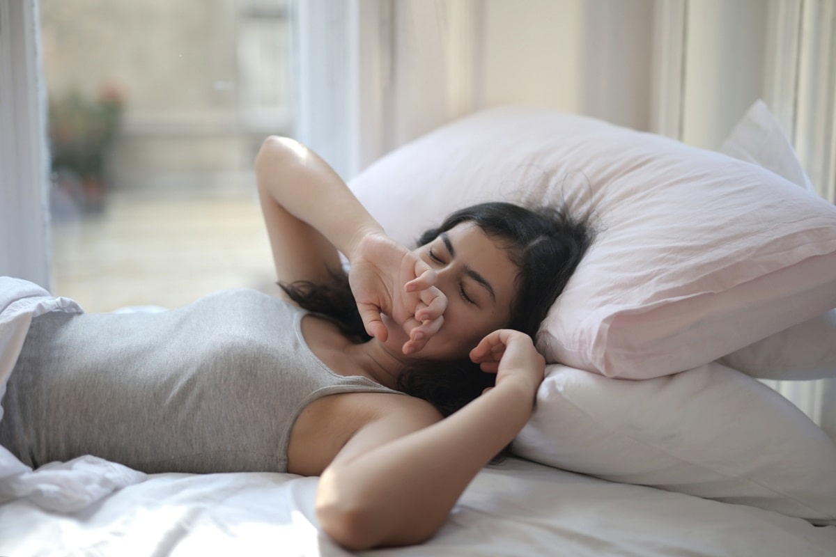 Woman lying in bed yawning.